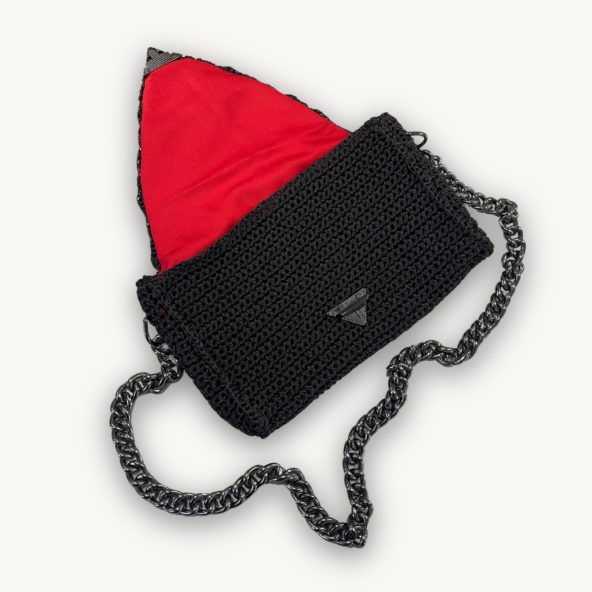 Crimson Eclipse black hand-knit clutch with crimson red lining, styled view