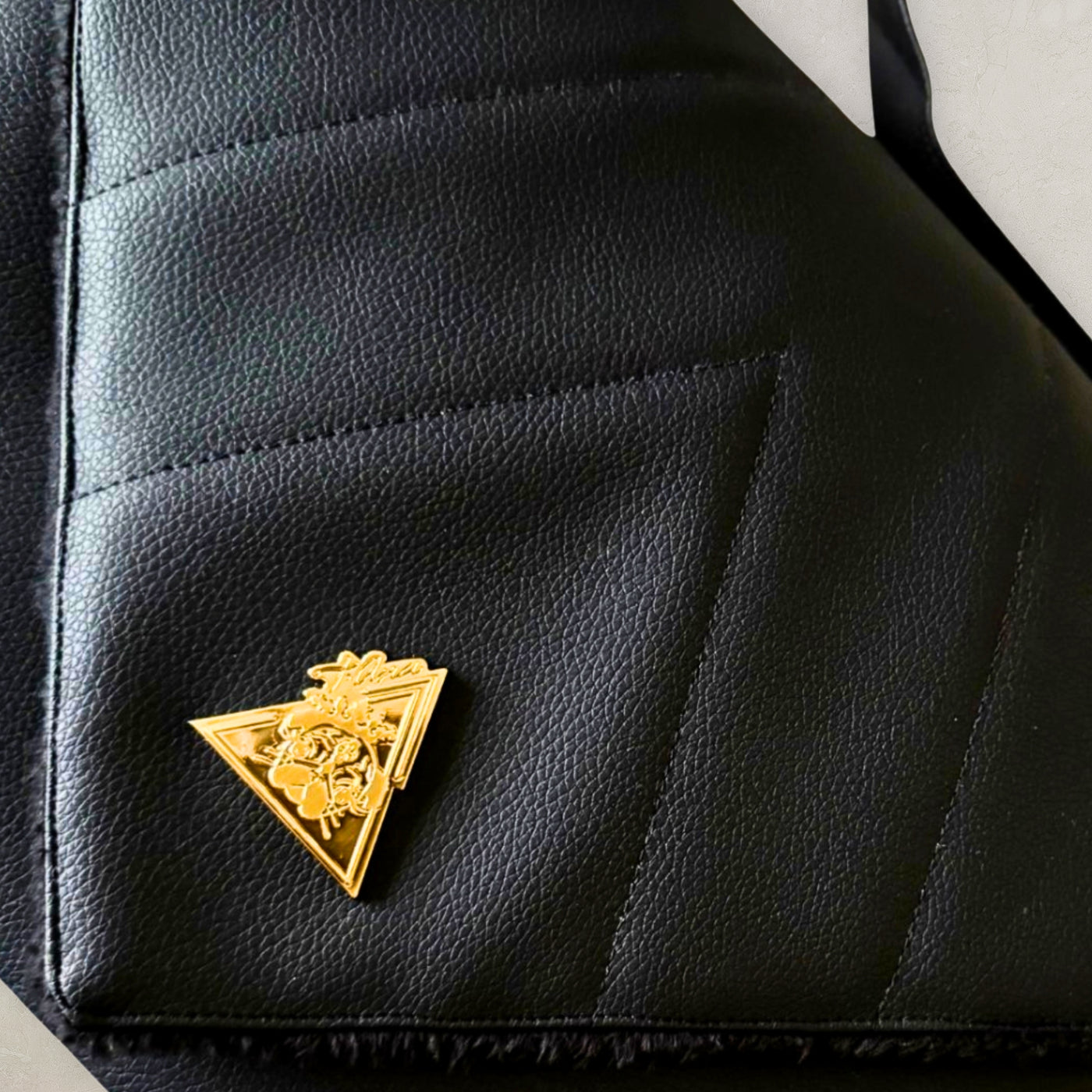 El Clásica Elysian Eclipse CarryAll Mini close-up with stitched panels and gold-tone emblem