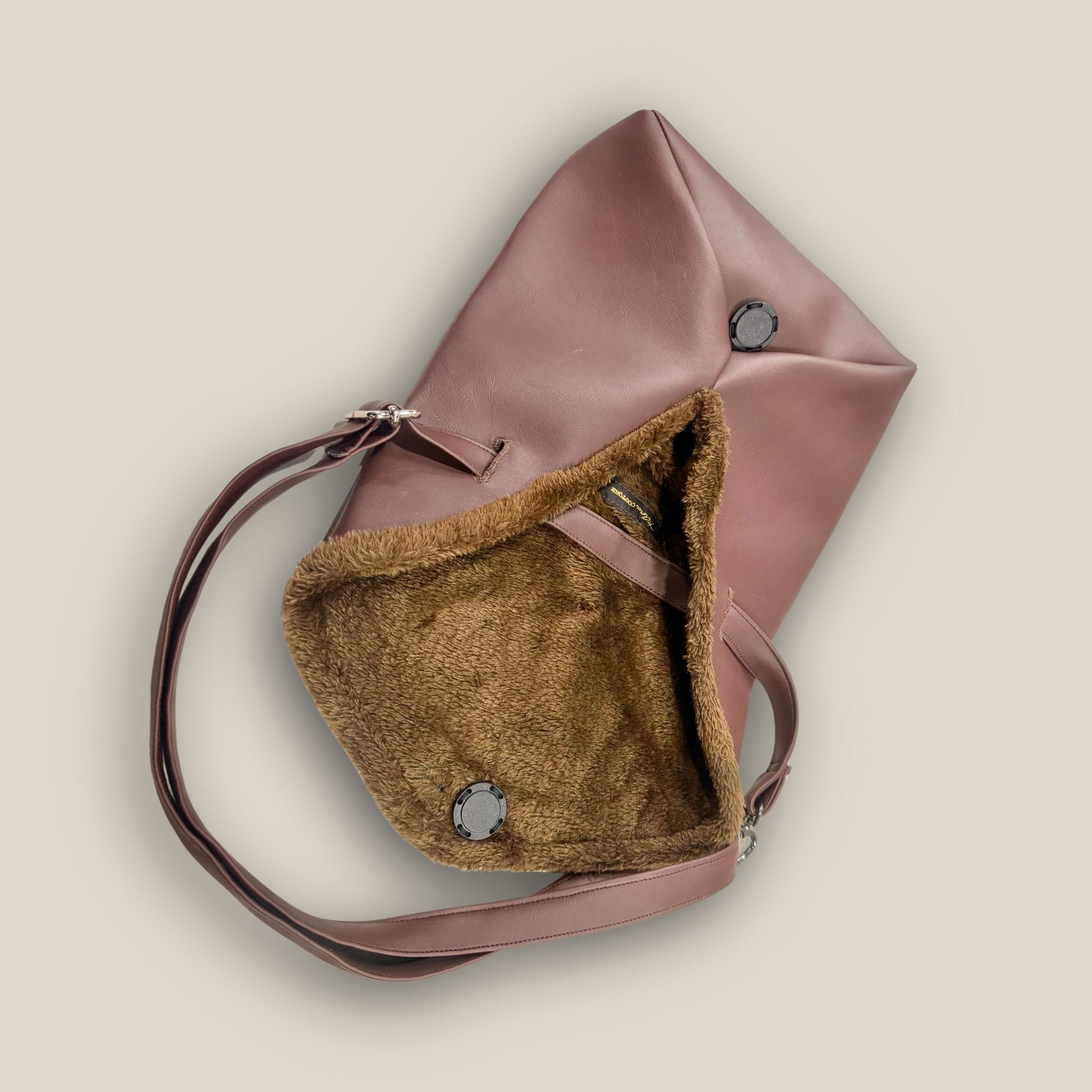 The Amara petite small brown bag from t•Ana Couture’s Chocolate Edit from the Amara Duo. Crafted in plush chocolate brown faux fur and finished with gold logo hardware, the Amara bags bring warmth, texture and refined slow luxury to any look. Each piece can be styled as a clutch, shoulder bag or crossbody, offering versatile day to evening wear. Here we feature the petite or small size bag. Here is the interior lining plush faux fur.