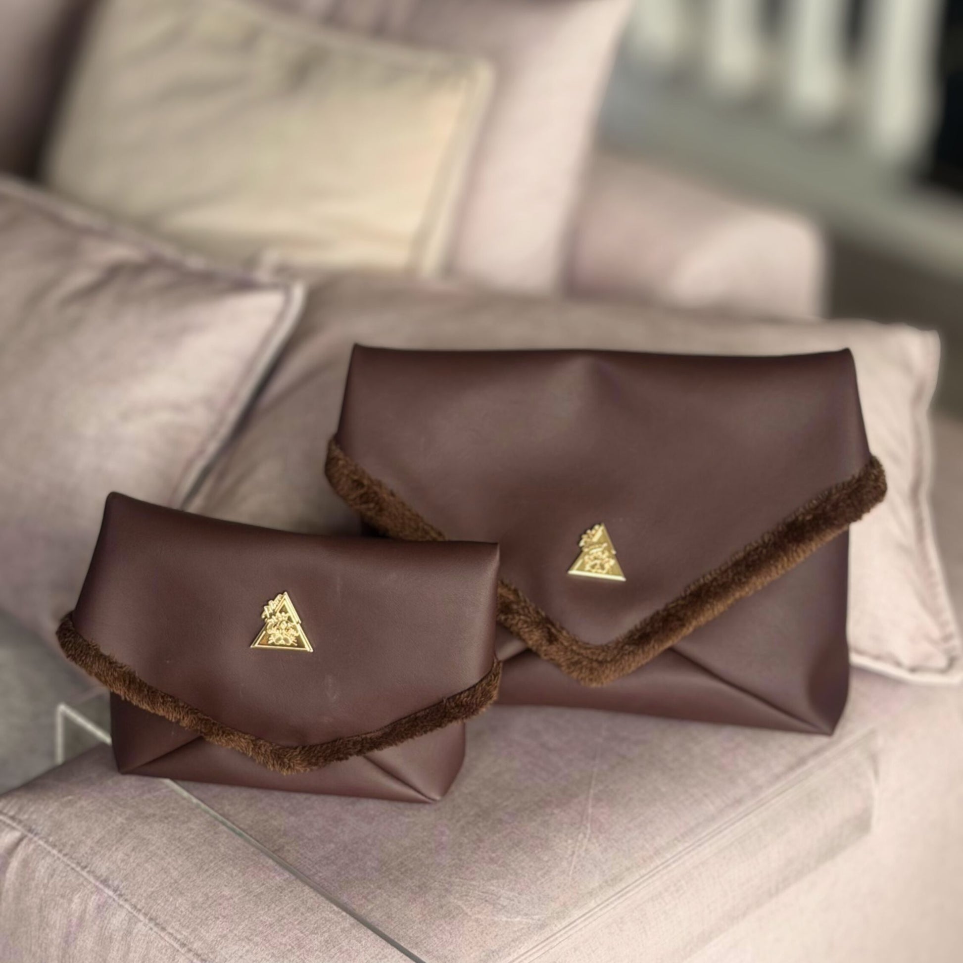 The Amara Duo from t•Ana Couture’s Chocolate Edit features two luxury multi wear clutch bags; one Grande and one Petite; designed to be worn together or individually. Crafted in plush chocolate brown faux fur and finished with gold logo hardware, the Amara bags bring warmth, texture and refined slow luxury to any look. Each piece can be styled as a clutch, shoulder bag or crossbody, offering versatile day to evening wear. 