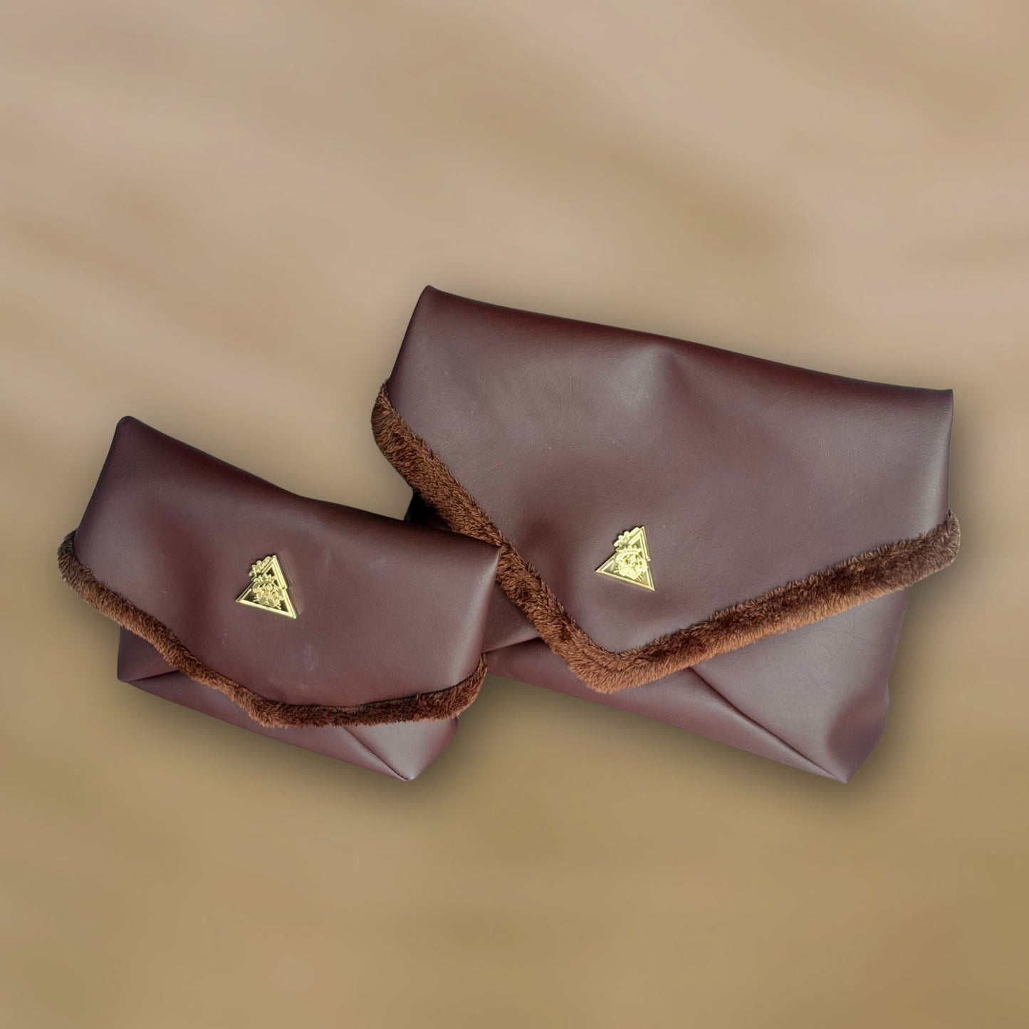 The Amara Duo from t•Ana Couture’s Chocolate Edit features two luxury multi wear clutch bags; one Grande and one Petite; designed to be worn together or individually. Crafted in plush chocolate brown faux fur and finished with gold logo hardware, the Amara bags bring warmth, texture and refined slow luxury to any look. Each piece can be styled as a clutch, shoulder bag or crossbody, offering versatile day to evening wear. 