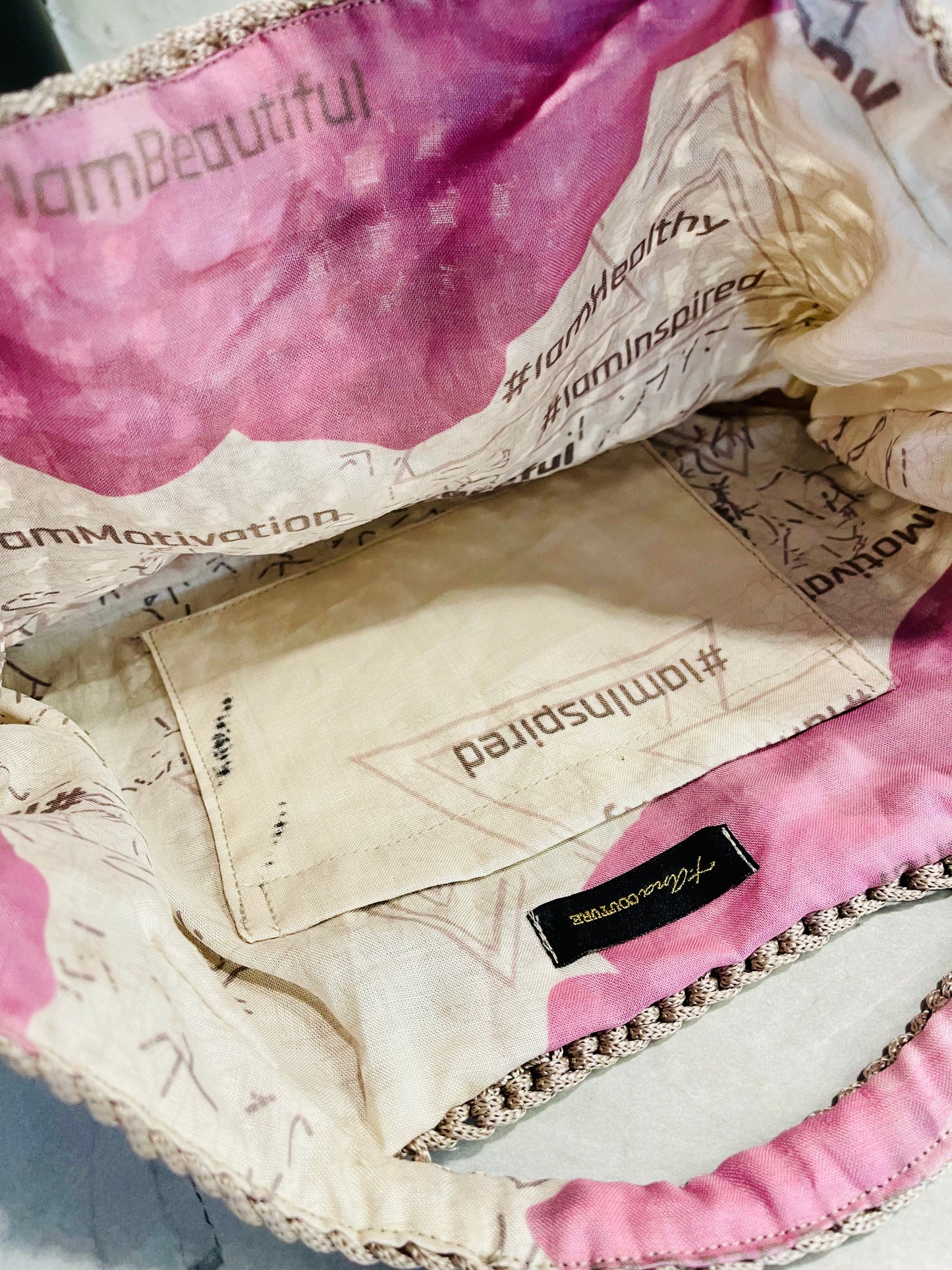 Interior of Mystic Mocha Bloom knit handbag showing organic linen floral lining with zinnia artwork symbolising lasting love, goodness and constancy; signature t.Ana Couture design. Organic linen interior lining of Mystic Mocha Bloom knit handbag featuring bespoke floral artwork, printed affirmations and Zinnia symbolism for lasting love, goodness and constancy; Threads of Heritage Mediterranean Muse Sand and Sea Tribute Collection by t.Ana Couture.