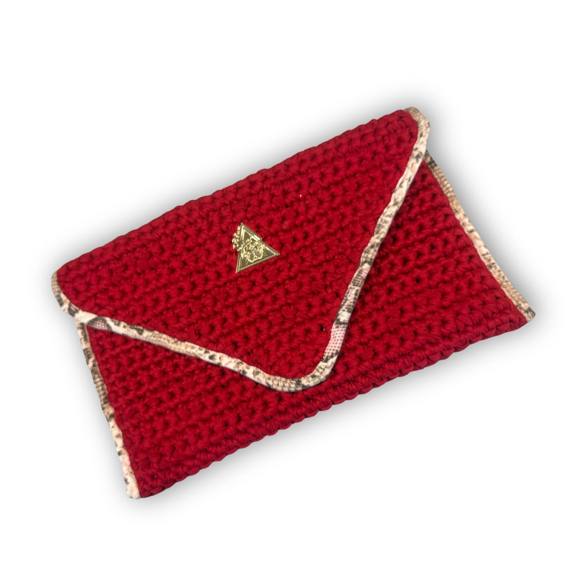 Sacred Venom Magenta Knit Clutch Handbag – magenta red knit clutch with gold logo and beige snake-print lining from t•Ana Couture’s Mediterranean Muse: Sand & Sea Collection; symbolizing passion, transformation, and divine feminine grace.