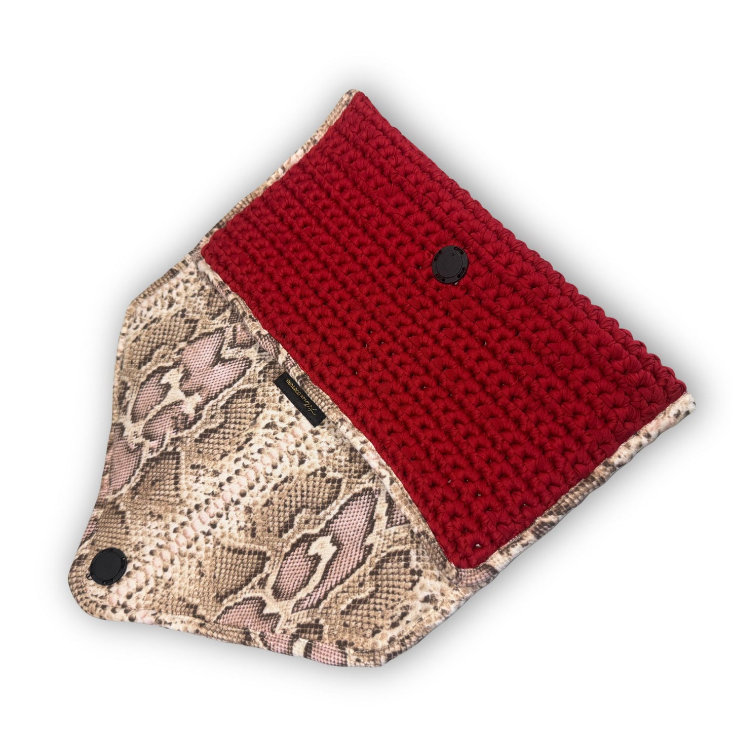 Sacred Venom Magenta Knit Clutch Handbag – magenta red knit clutch with gold logo and beige snake-print lining from t•Ana Couture’s Mediterranean Muse: Sand & Sea Collection; symbolizing passion, transformation, and divine feminine grace.