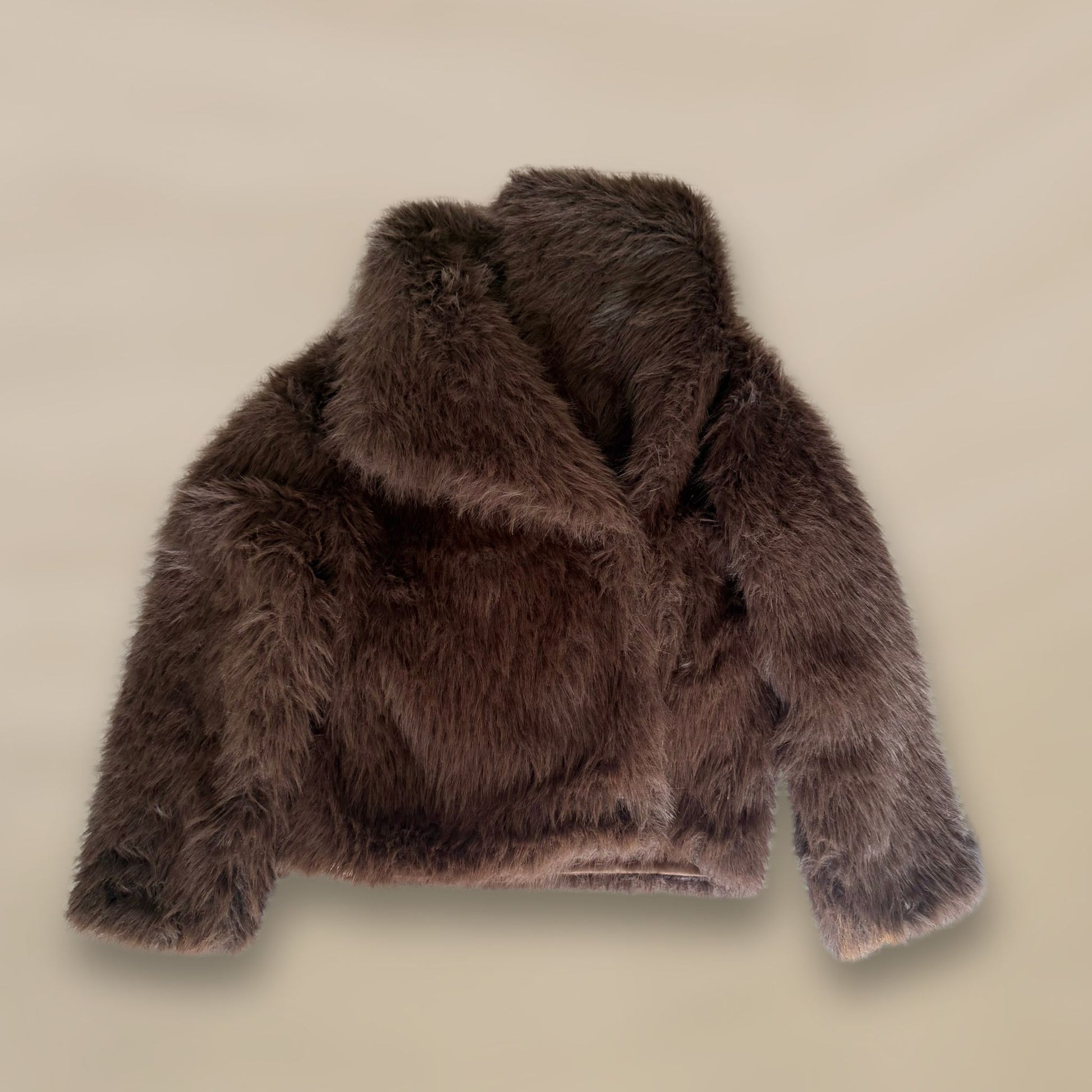 Soft brown faux fur coat featuring natural wooden buttons and practical pockets; a plush, cosy and elegant neutral outerwear piece for women, designed for slow luxury winter styling and refined day to evening looks. This warm, timeless coat elevates everyday outfits with texture, comfort and effortless sophistication.