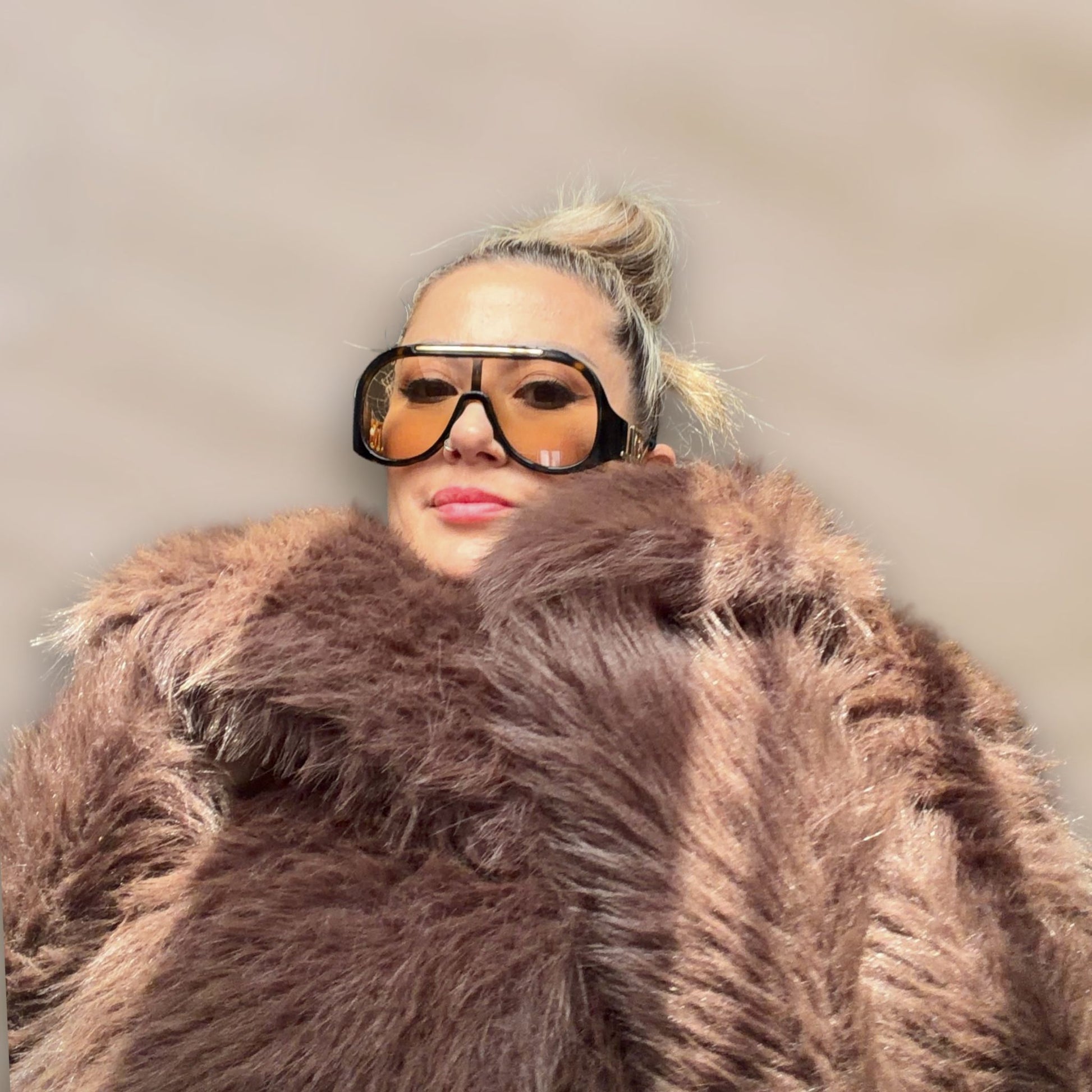 Soft brown faux fur coat featuring natural wooden buttons and practical pockets; a plush, cosy and elegant neutral outerwear piece for women, designed for slow luxury winter styling and refined day to evening looks. This warm, timeless coat elevates everyday outfits with texture, comfort and effortless sophistication. Close up.