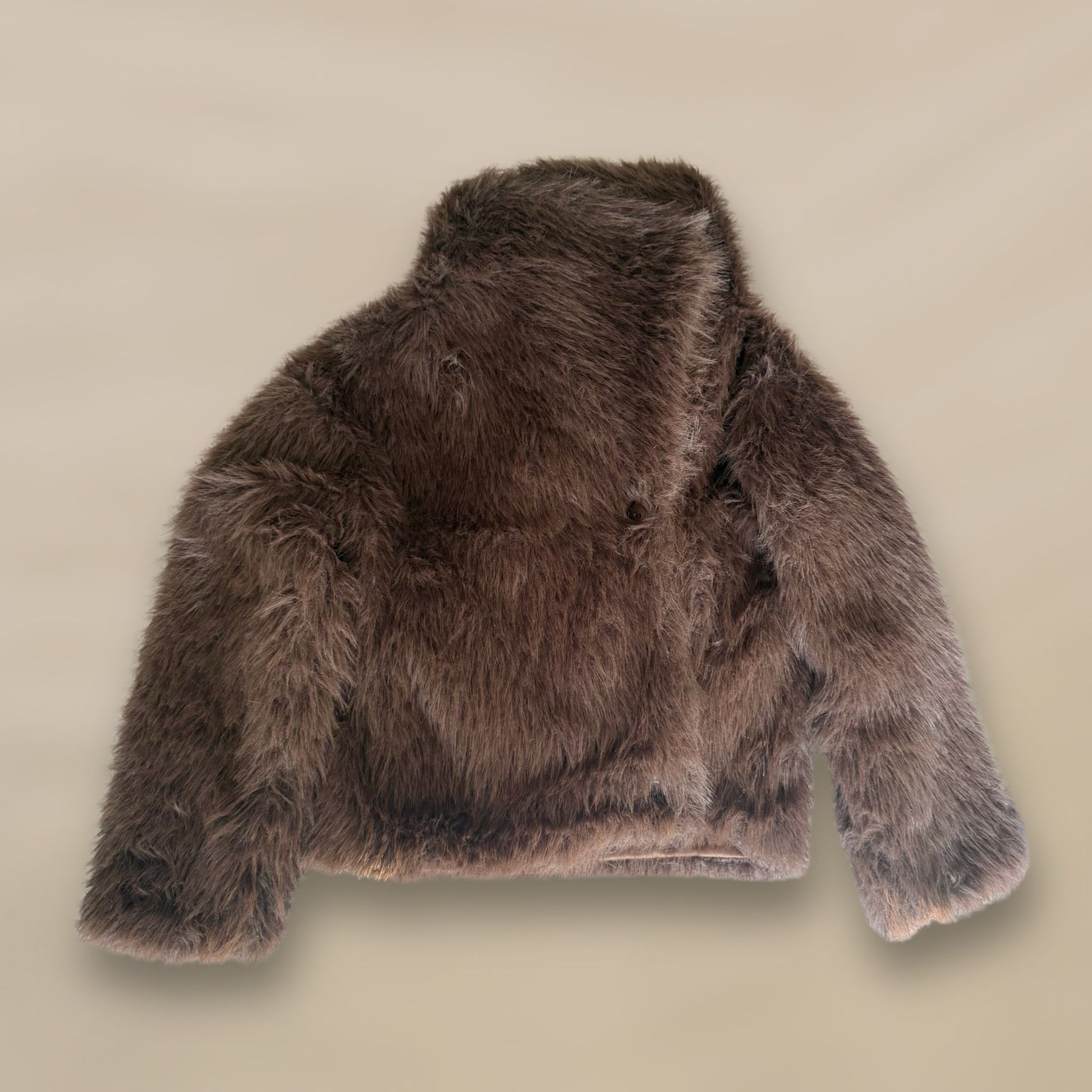 Soft brown faux fur coat featuring natural wooden buttons and practical pockets; a plush, cosy and elegant neutral outerwear piece for women, designed for slow luxury winter styling and refined day to evening looks. This warm, timeless coat elevates everyday outfits with texture, comfort and effortless sophistication.