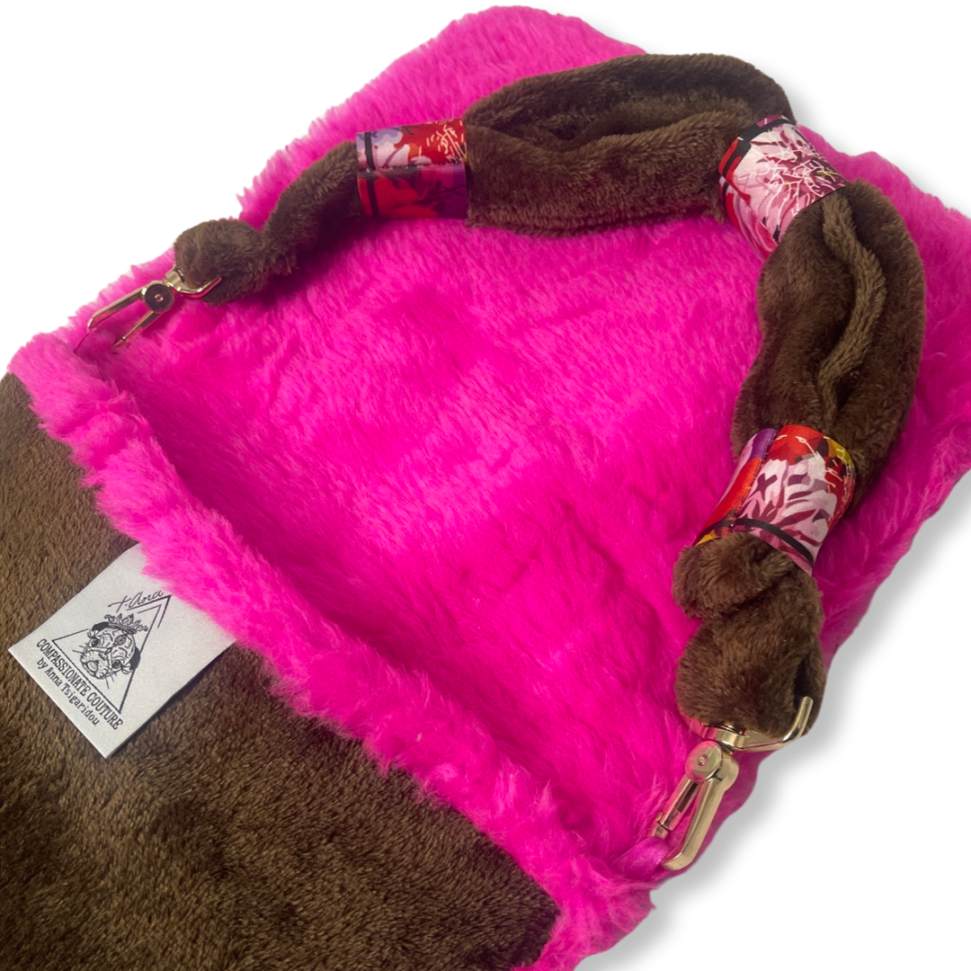 t•Ana Couture LA SnugglePlush Elegante handbag in brown faux fur with bold pink plush trim and LA lettering; luxury statement clutch styled with cream coat; sustainable upcycled design with modern street-luxe elegance.
