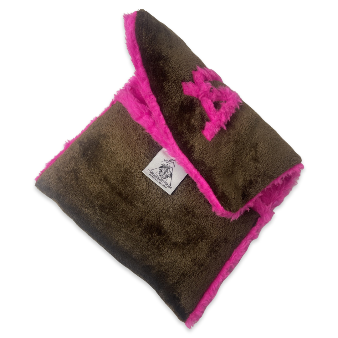 t•Ana Couture LA SnugglePlush Elegante handbag in brown faux fur with bold pink plush trim and LA lettering; luxury statement clutch styled with cream coat; sustainable upcycled design with modern street-luxe elegance.